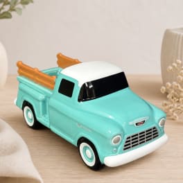 Turquoise ceramic pickup truck planter on a wooden surface