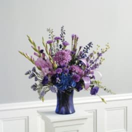 Purple and blue flower arrangement in a dark blue vase