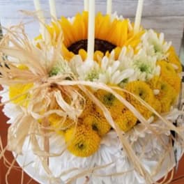 Sunflower and white daisy arrangement with straw ribbon and candles