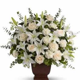 White lilies and cream roses arranged in a brown urn