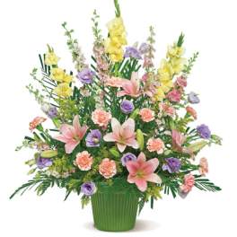 Mixed bouquet of lilies, carnations, and purple blooms in a green vase