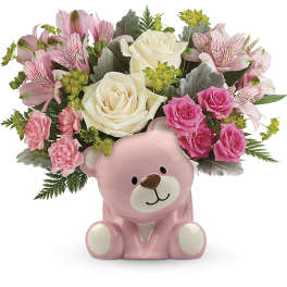 Pink teddy bear vase holding pink and white flowers