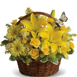 Yellow flowers arranged in a wicker basket with a butterfly decoration