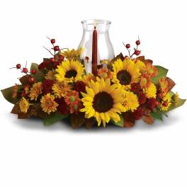 Sunflower and mum centerpiece with a glass hurricane candle holder