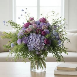 Purple and lavender bouquet in a clear glass vase