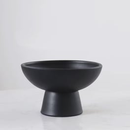 Black pedestal bowl vase on a white surface