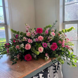 Large pink and magenta rose arrangement with mixed blooms on a table