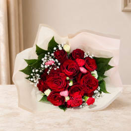 Bouquet of red roses with white filler flowers and pink accents