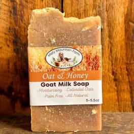 Bar of oat and honey goat milk soap with a paper label