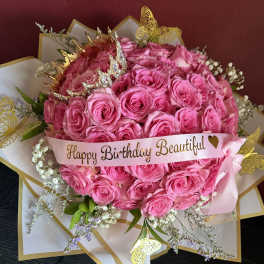 Pink rose bouquet with a birthday ribbon and butterfly decorations