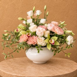 Mixed pastel flower arrangement in a white bowl vase