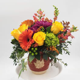 Colorful mixed flower arrangement in a decorative ceramic pot