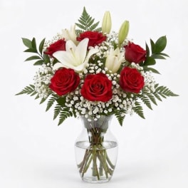 Red roses and white lilies arranged in a clear glass vase
