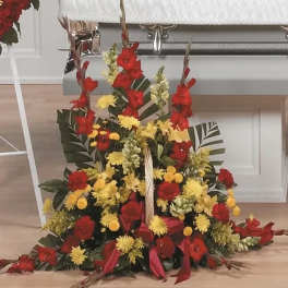 Large red and yellow floral arrangement with ribbon accents
