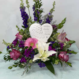 Sympathy floral arrangement with pink and purple flowers and an angel memorial plaque