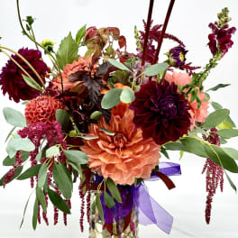 Colorful dahlia arrangement in a glass vase with ribbon