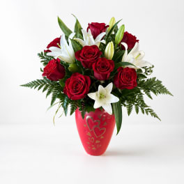 Red roses and white lilies in a red heart-decorated vase