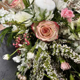 Floral centerpiece with a glass candle holder and pink rose
