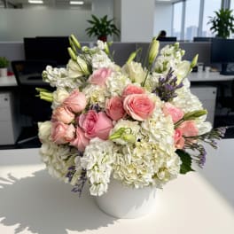 Pink and white roses with hydrangeas in a white vase