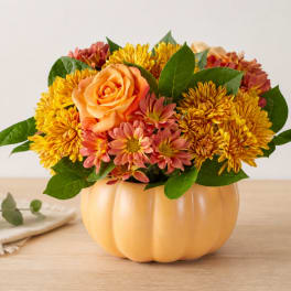 Orange rose and yellow chrysanthemum arrangement in a pumpkin-shaped container