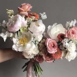 Hand-tied bouquet of pink and white flowers with a ribbon wrap