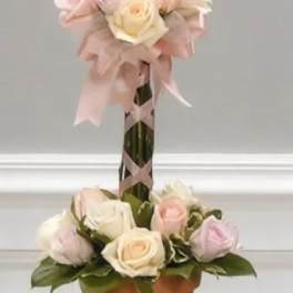 Two-tier rose arrangement in a terracotta pot with pink ribbon