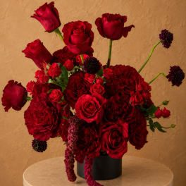 Red roses and carnations arranged in a black vase