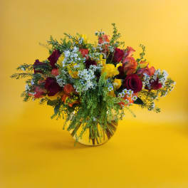 Mixed bouquet of roses and small white flowers in a round vase