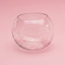 Clear round glass vase on a pink background