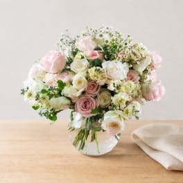 Pink and white roses arranged in a clear glass vase