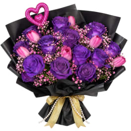 Purple roses and pink tulips in black wrap with a gold ribbon and heart pick