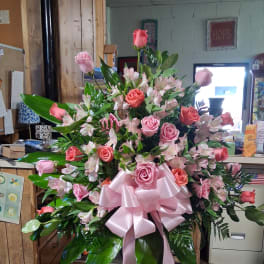 Large pink rose and lily arrangement with a pink ribbon bow