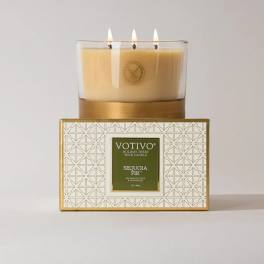 Three-wick candle in a glass jar on a patterned box