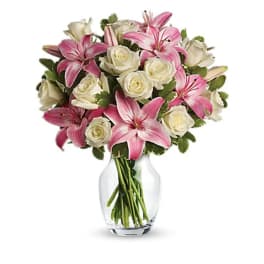 Pink lilies and white roses in a clear glass vase