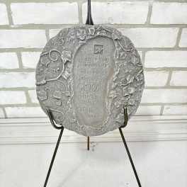 Gray decorative plaque on a metal stand with an inspirational quote