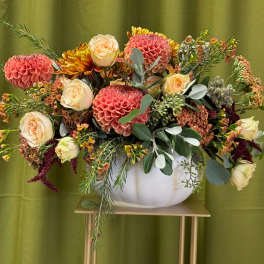 Mixed bouquet of pink dahlias and cream roses in a white vase