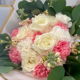 Bouquet of white roses and pink carnations with greenery