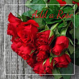 Red roses with green foliage on a wood background