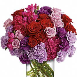 Bouquet of red, pink, and purple flowers in a clear glass vase