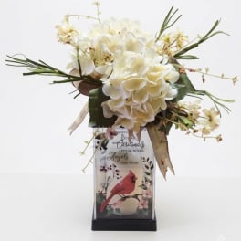 Cream floral arrangement in a decorative vase with a bird design
