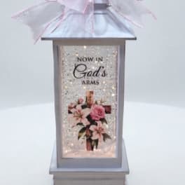 Decorative lantern with a pink bow and floral print panel