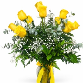 Yellow roses arranged in a glass vase with white filler flowers