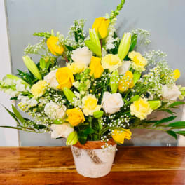 Yellow and white rose bouquet in a rustic pot