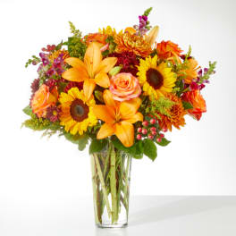 Orange and yellow mixed bouquet in a clear glass vase