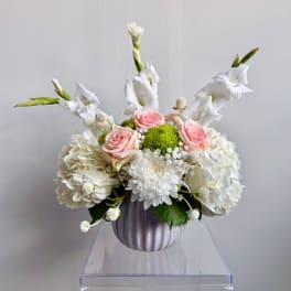 White and pink floral arrangement in a ribbed vase
