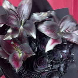 Dark roses and lilies in a black bouquet with pink accents