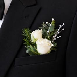 White rose boutonniere pinned to a black suit jacket