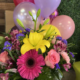 Bright mixed bouquet with yellow lily, pink gerbera, roses, and balloons