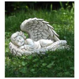 Stone angel statue lying in grass outdoors
