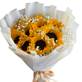 Bouquet of sunflowers wrapped in white paper with a peach ribbon